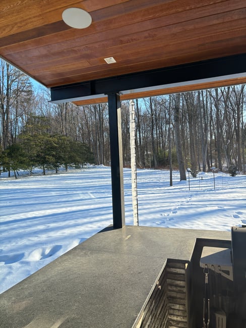 Modern Custom Home by AV Architects and Builders in Great Falls Virginia in the wintertime with snow modern rain chain covered in ice
