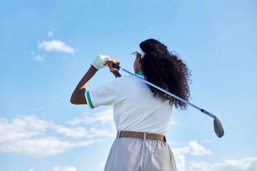 back-view-of-black-young-woman-playing-golf-agains-2023-11-27-05-28-11-utc
